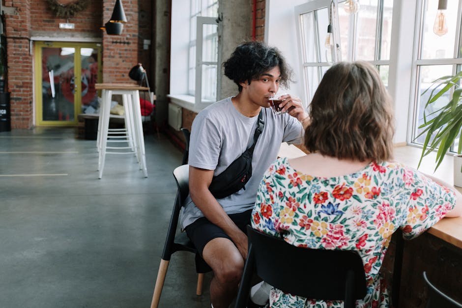 Young adults enjoy a relaxed conversation and coffee in a stylish urban café.