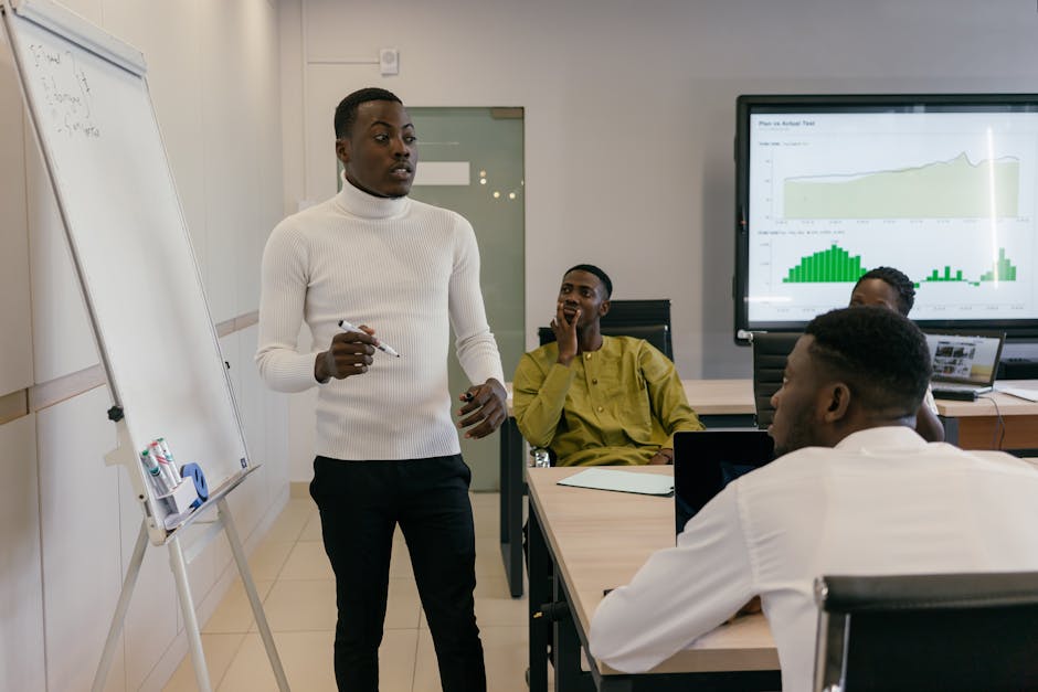 Group of professionals discussing business strategy during a presentation in a bright, modern workspace.