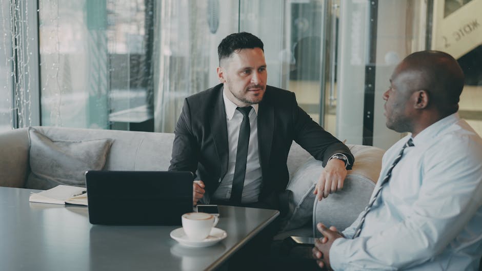 Two businessmen engaging in a discussion over coffee. Professional and focused atmosphere.
