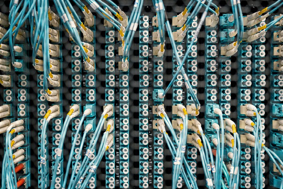 Top view of fiber optic cables connected to ports in modern data server