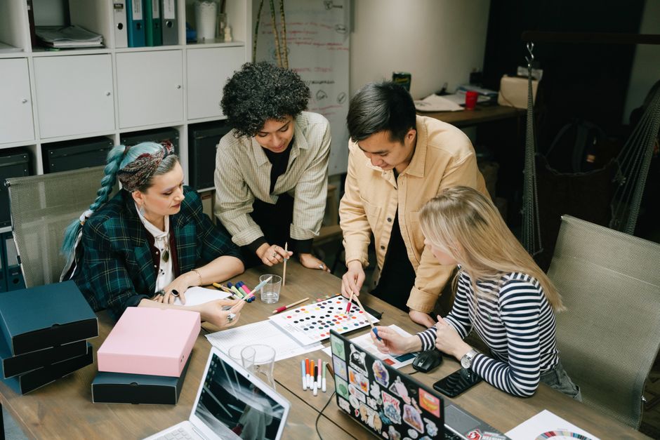 A diverse team collaborating on a project in a modern office setting, showcasing teamwork and creativity.
